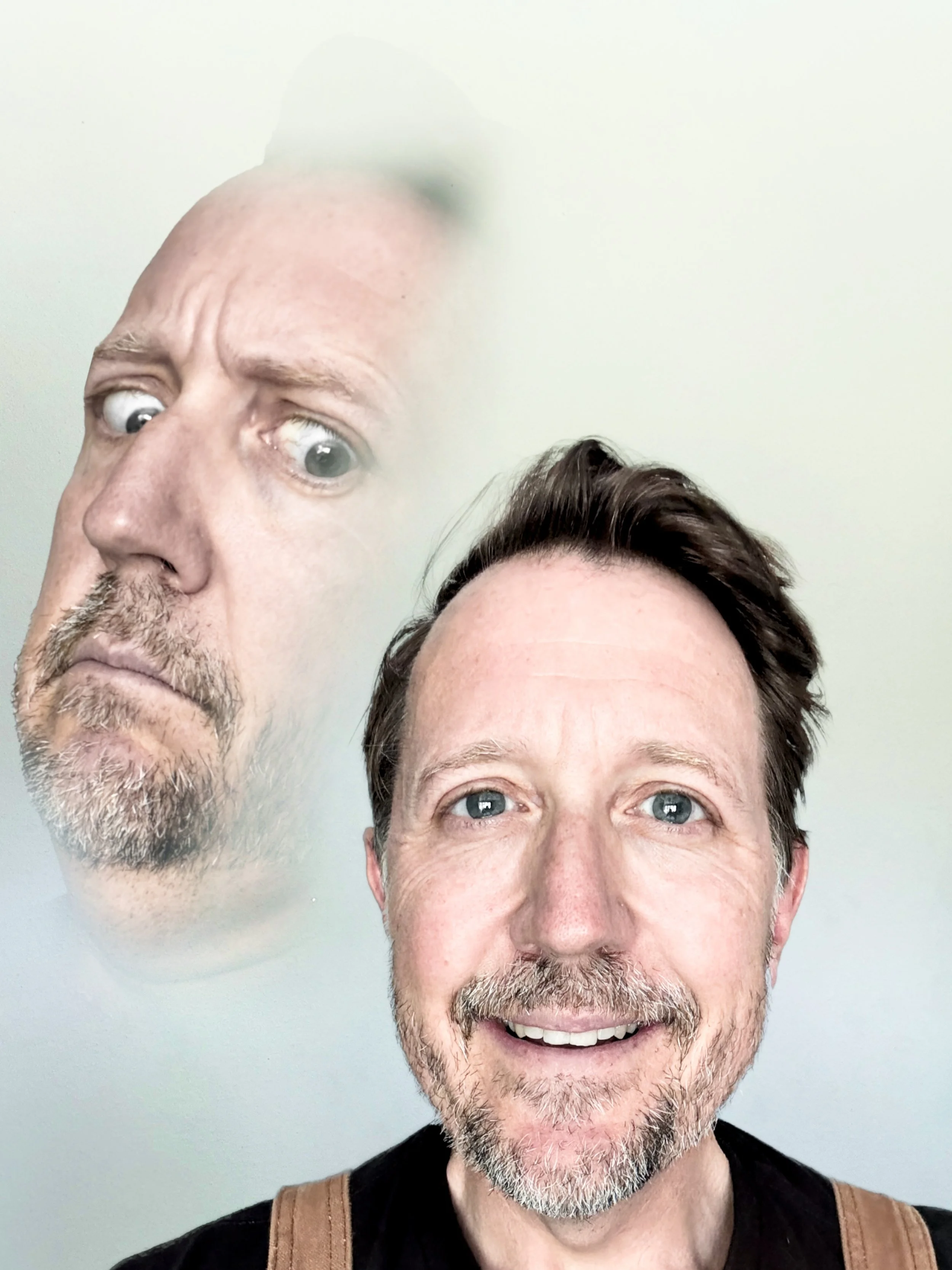 Lance C. Fuller, double exposure — a calm smiling portrait with a larger, horrified ghost version of himself looming overhead, 70s family-portrait style